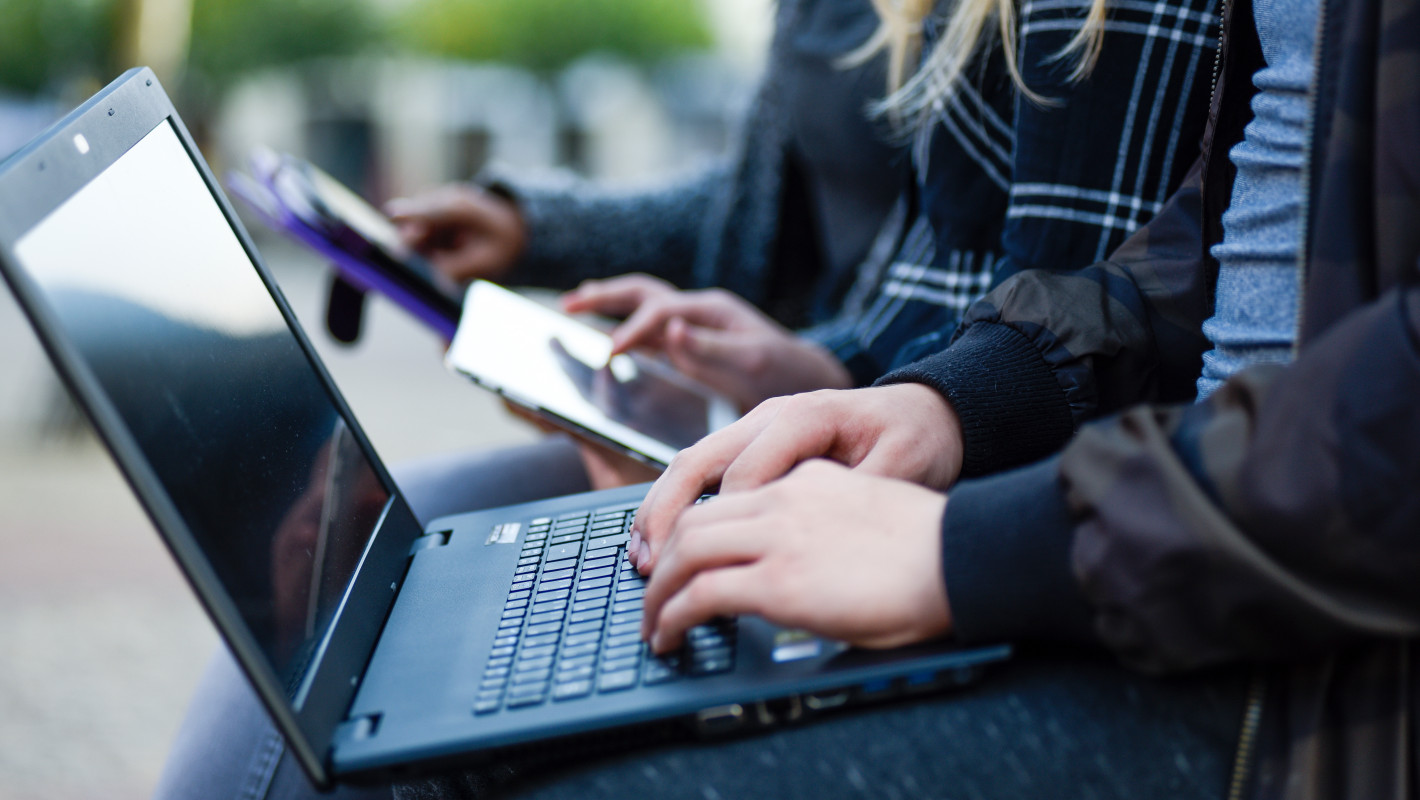 Personen die Laptop, Tablet und Smartphone benutzen