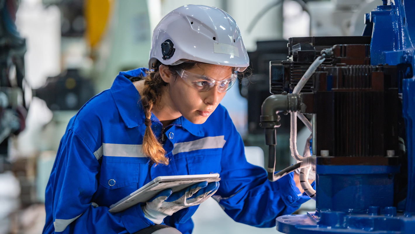 Ingenieurin prüft eine Maschine in einer Fabrik