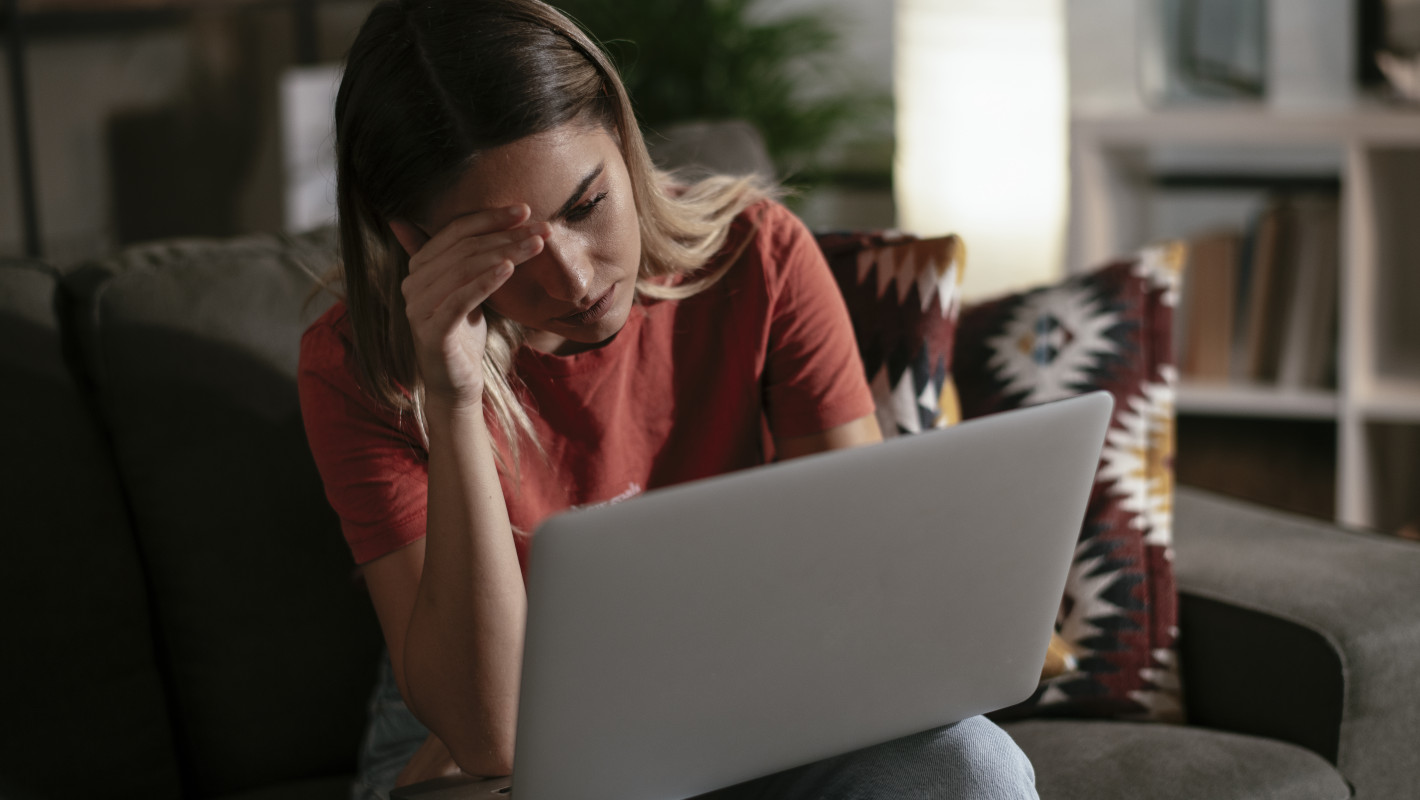 Frau sitzt traurig vor dem Laptop