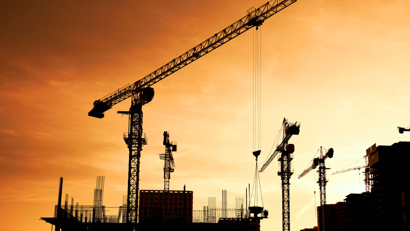 Baustelle mit Kran bei Sonnenuntergang