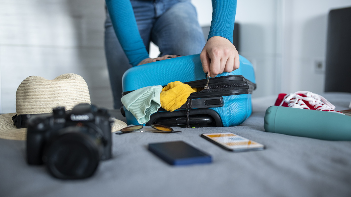 Frau packt ihren Koffer für den Urlaub
