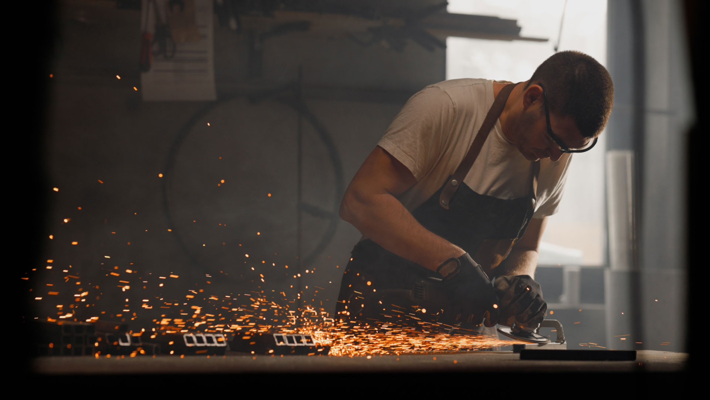 Schlosser schleift ein Metallstück
