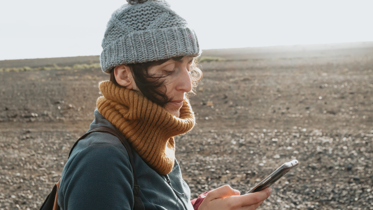 Reisende Frau die ihr Smartphone benutzt