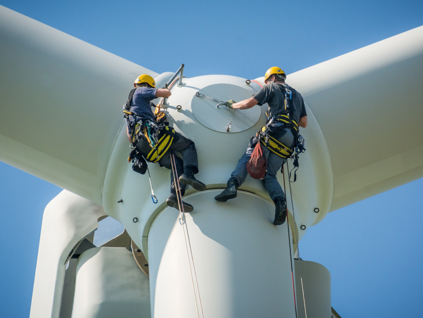 2 Arbeiter die sich von einer Windmühle abseilen