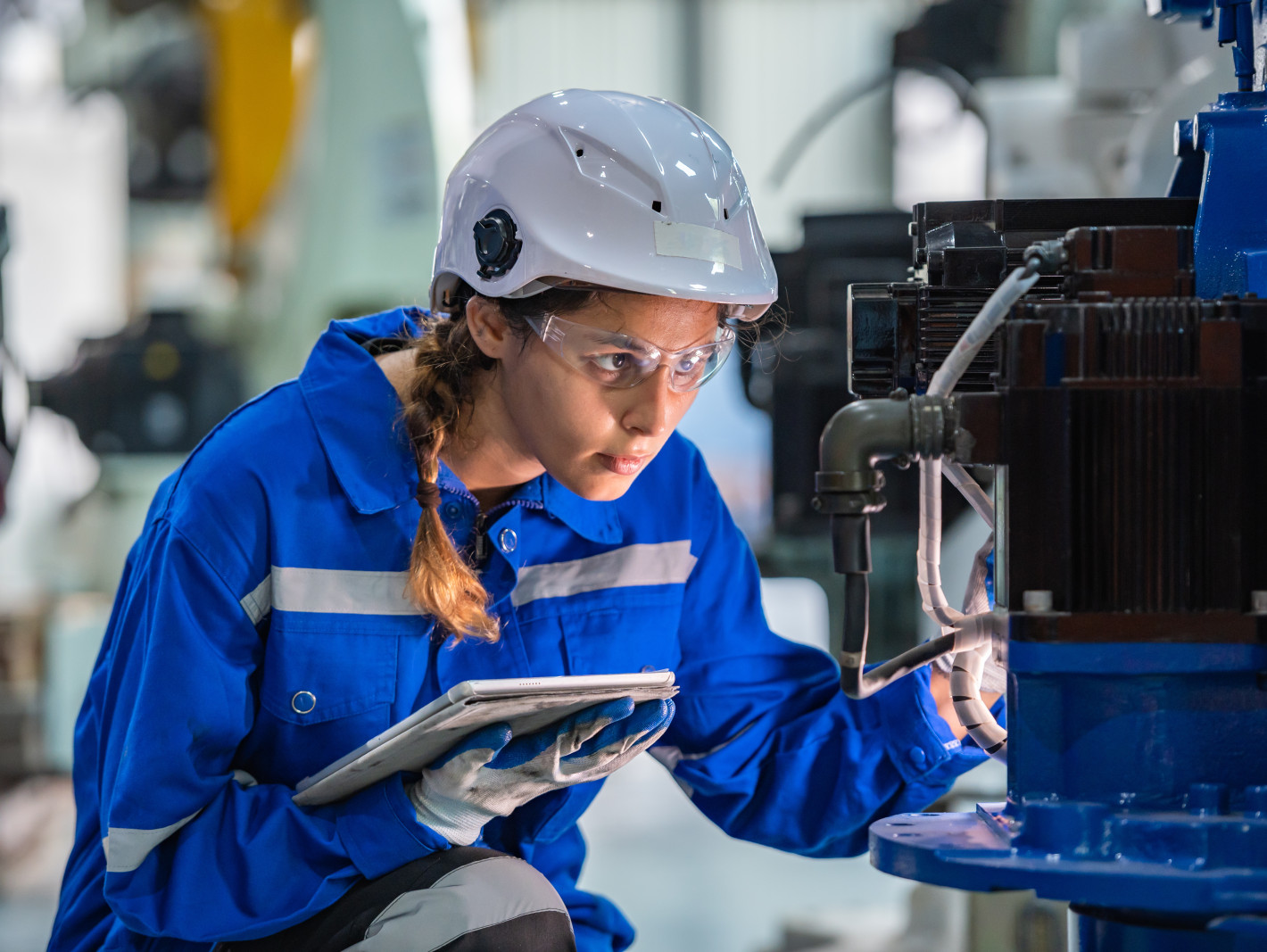 Ingenieurin prüft eine Maschine in einer Fabrik