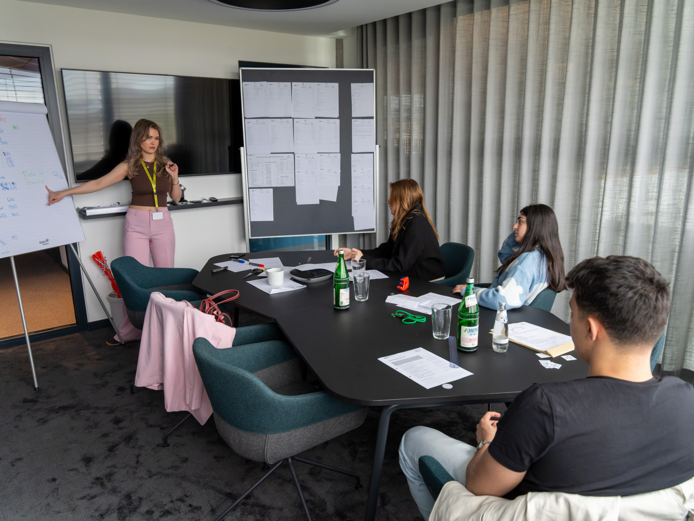 Vier Teilnehmende in der Beratung; ein Mädchen steht am Flipchart