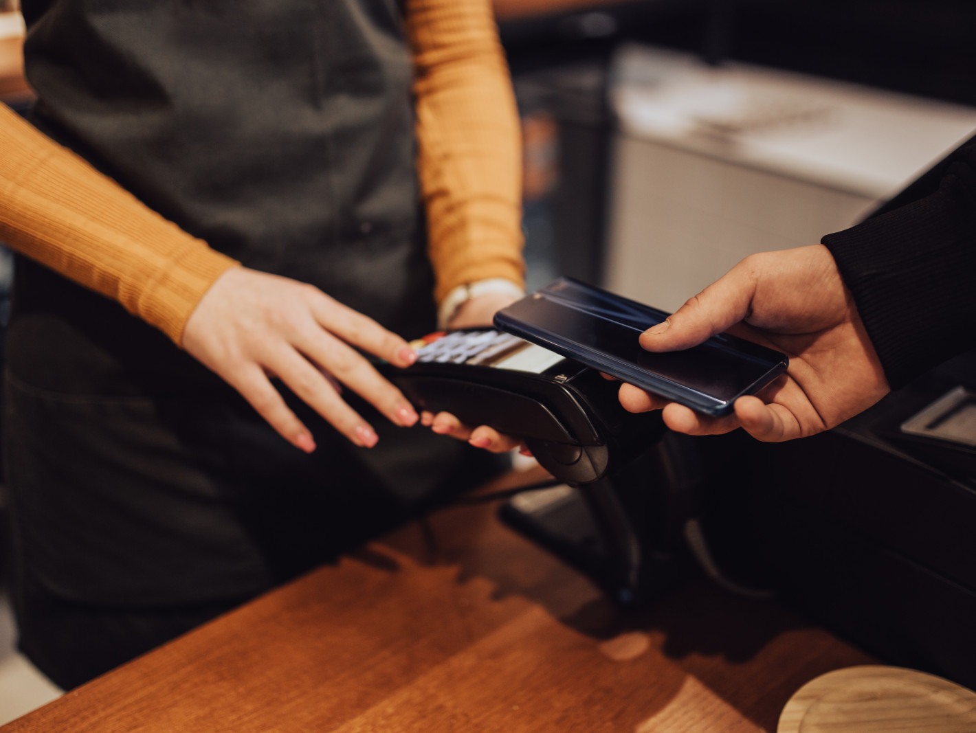 Mann bezahlt kontaktlos in einem Laden