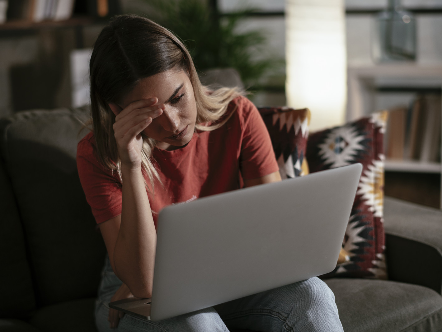Frau sitzt traurig vor dem Laptop