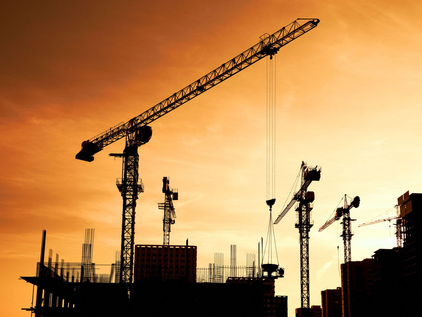 Baustelle mit Kran bei Sonnenuntergang