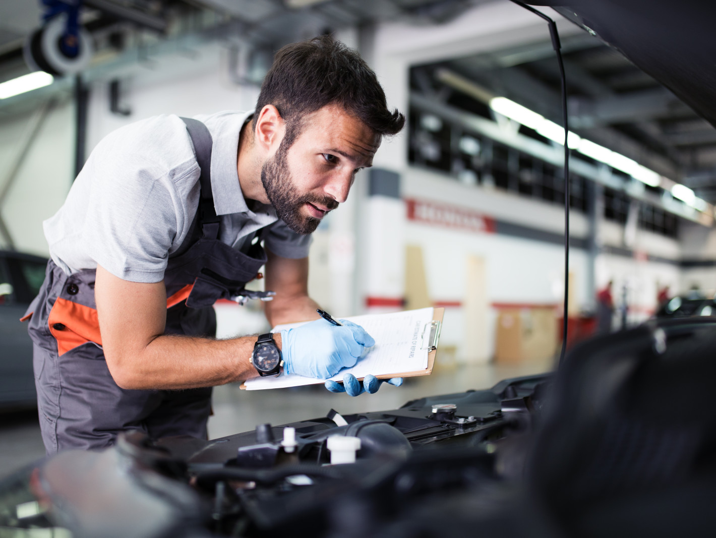 Arbeiter kontrolliert den Motor an einem Auto