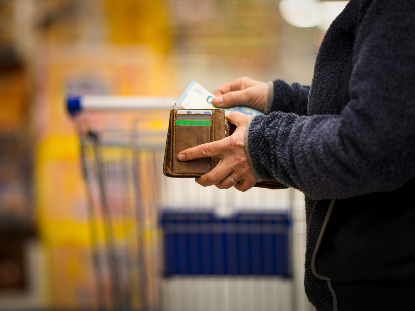 Mann der Geld aus seinem Portemonnaie nimmt