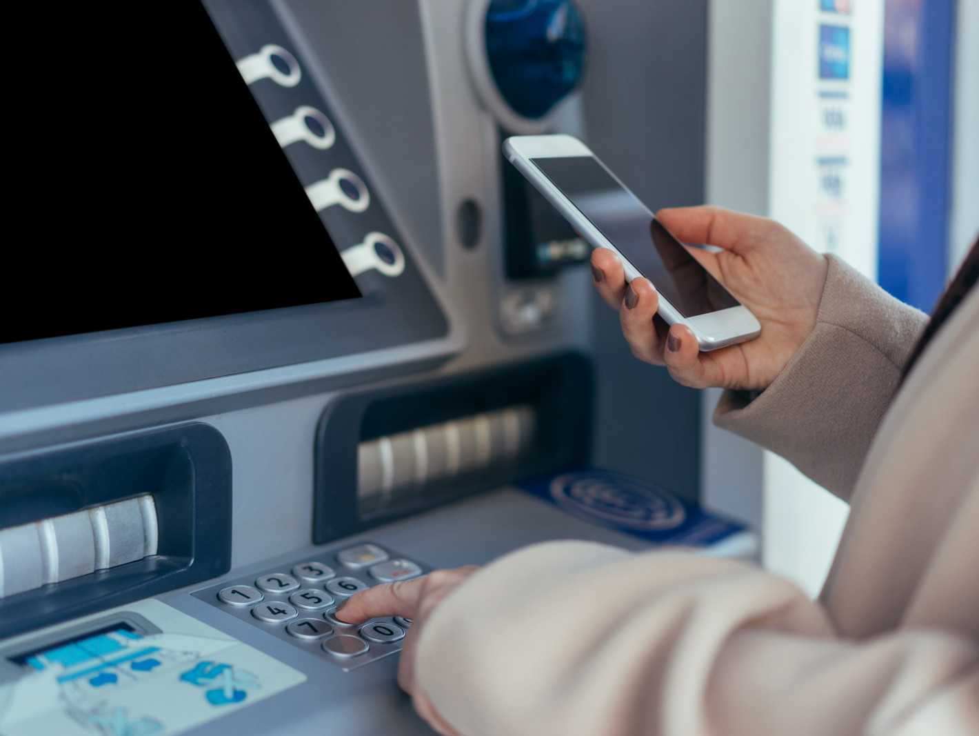 Frau hebt Geld ab mit Smartphone