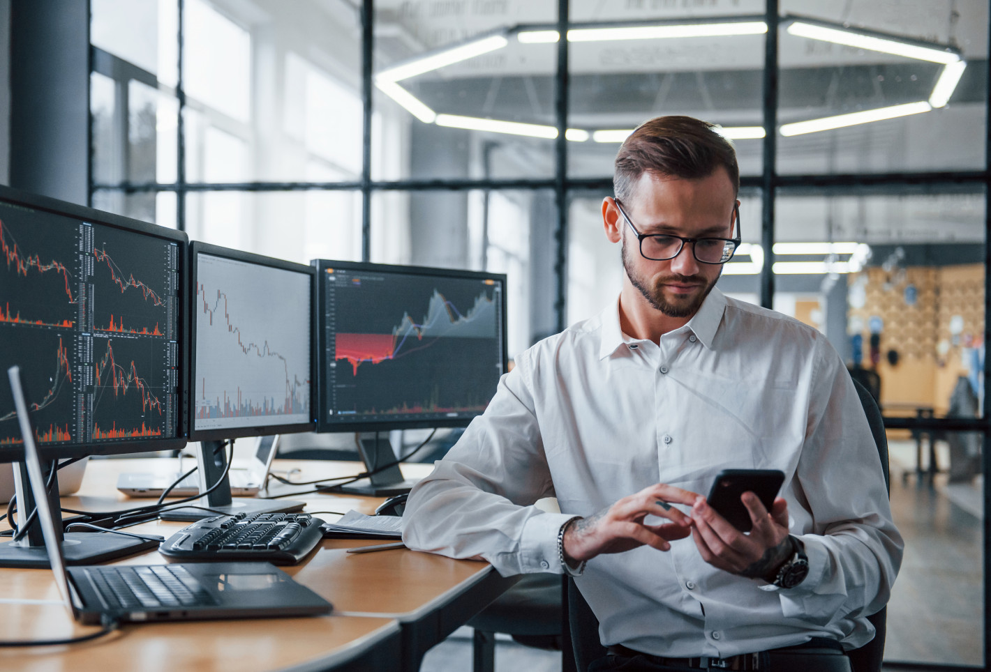 Stockbroker checks his smartphone