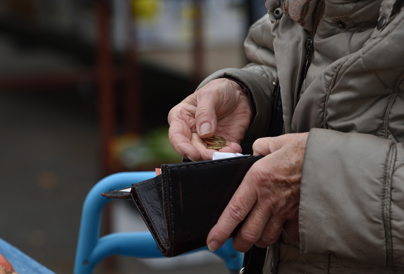 Alter Mann zählt Geld in seinem Portemonnaie