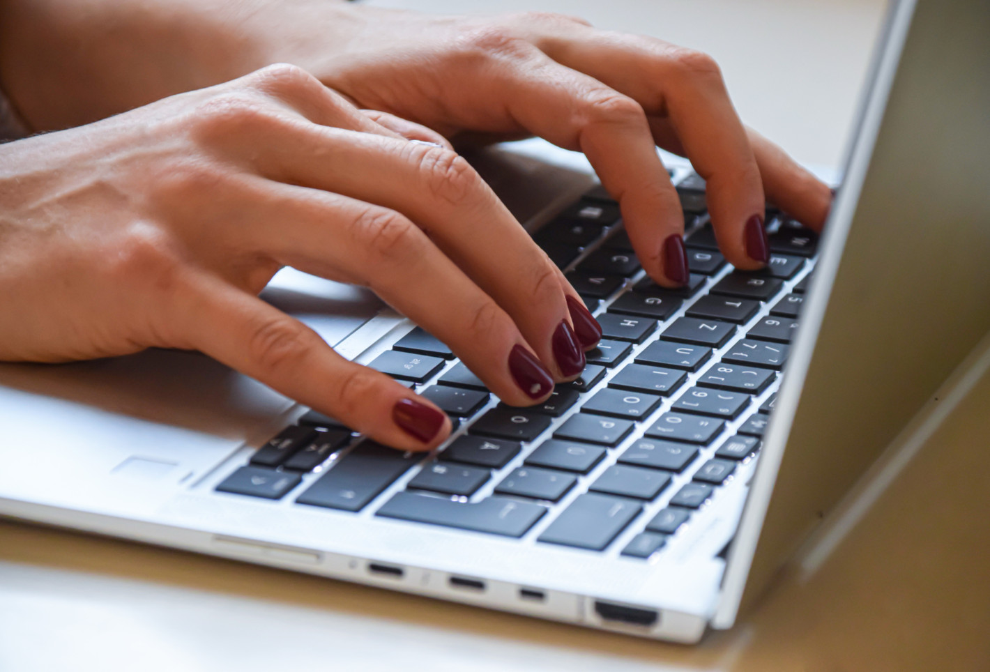 Nahaufnahme von einer Frau die am Laptop arbeitet